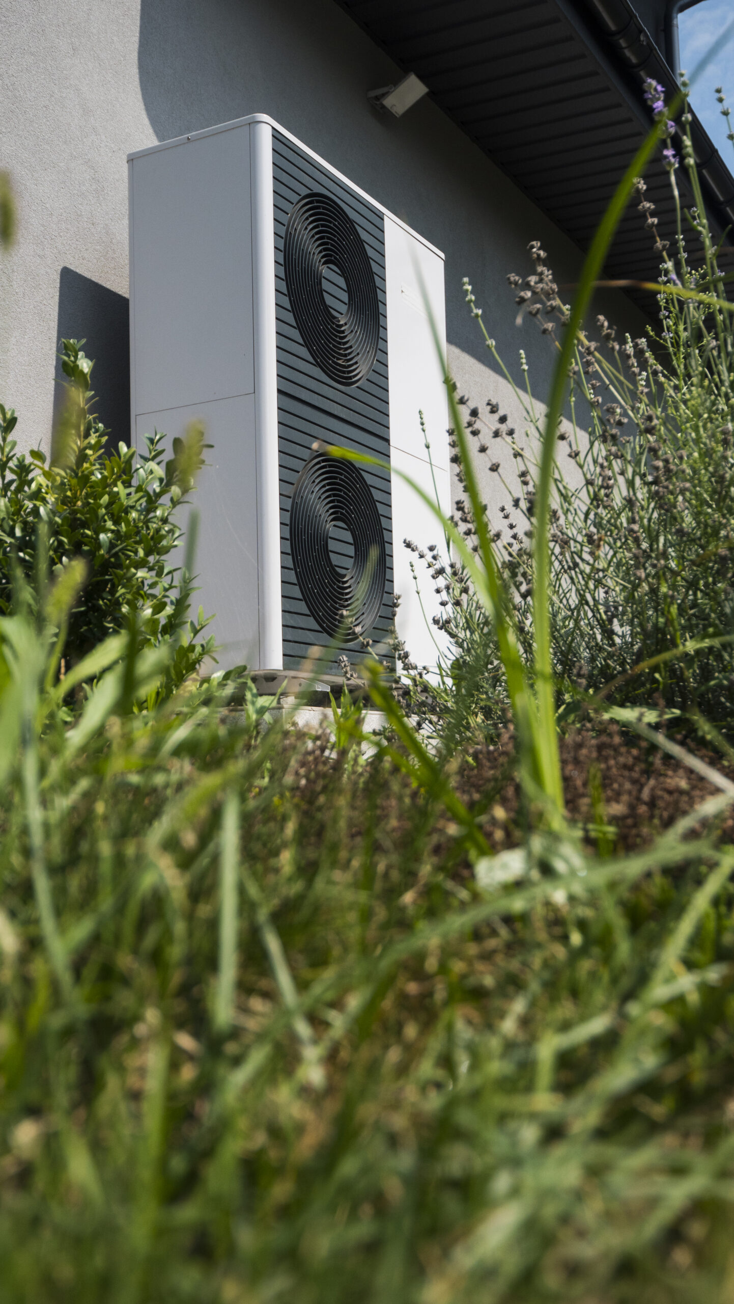 Unité extérieure de pompe à chaleur air-eau contre un mur de maison